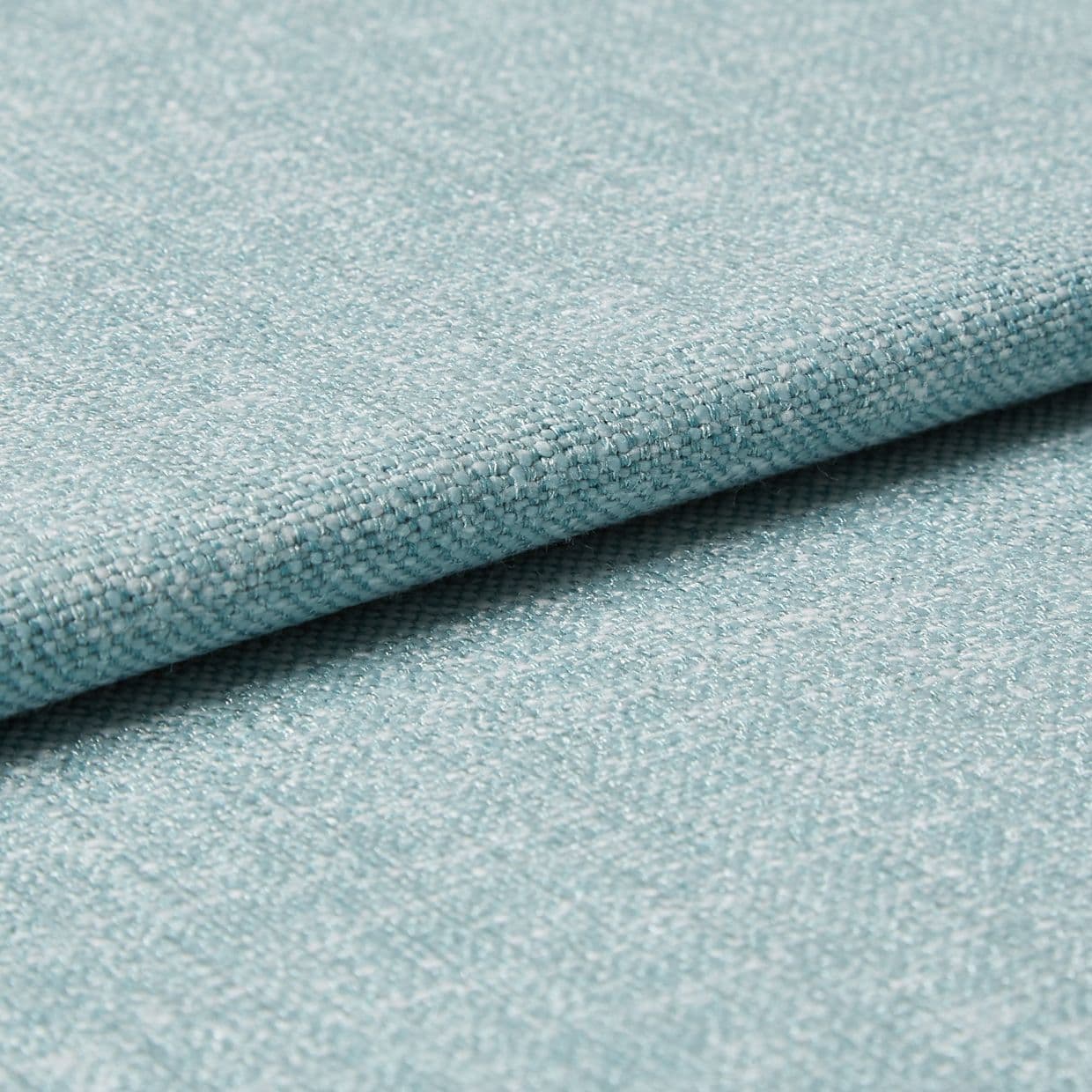 Light-blue woven upholstery fabric folded so one edge overlaps, revealing tight textured weave; photographed as a close-up on a flat surface with soft, even studio lighting for a material sample.