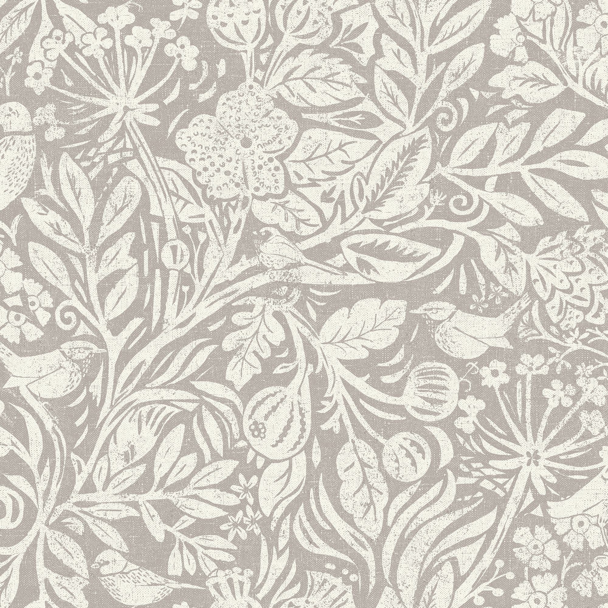Beige wallpaper with cream, distressed botanical printâ€”stylized leaves, flowers, seed pods and small birdsâ€”decorating a surface; close-up view with even, neutral lighting.