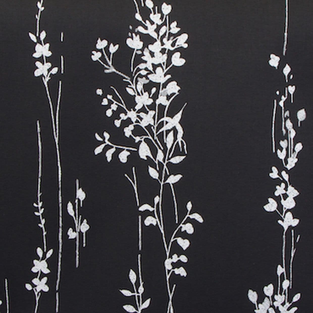Vertical white floral-vine pattern printed in thin sketch-like lines on matte black fabric or wallpaper, close-up view showing a high-contrast, minimalist decorative surface.