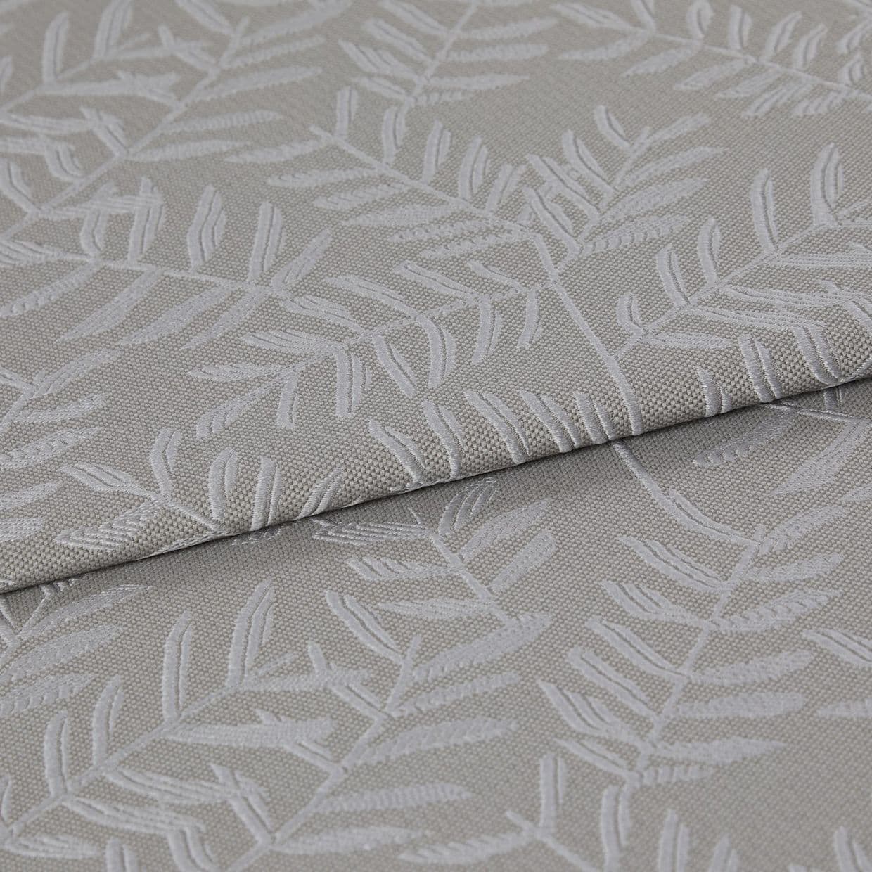 Beige-gray woven fabric with raised white botanical leaf pattern, folded once and layered, displaying texture and subtle sheen; close-up on textile surface under soft, neutral lighting.
