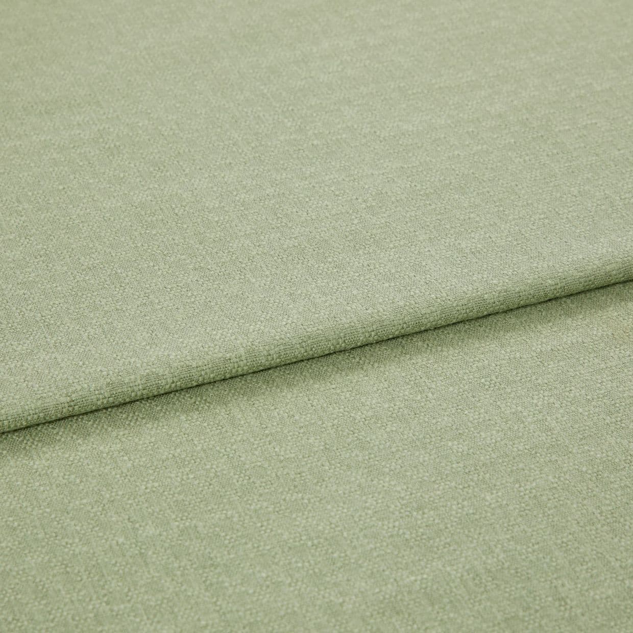 Pale green woven fabric folded once, showing a horizontal overlap and subtle textured weave; lying flat in soft, even studio lighting with a neutral background.