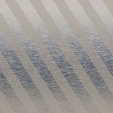 Diagonal-striped fabric window blind across the frame, alternating opaque beige and semi-translucent gray bands; filtering daylight and casting muted banded shadows; softly lit interior with a subtle textured surface visible behind.