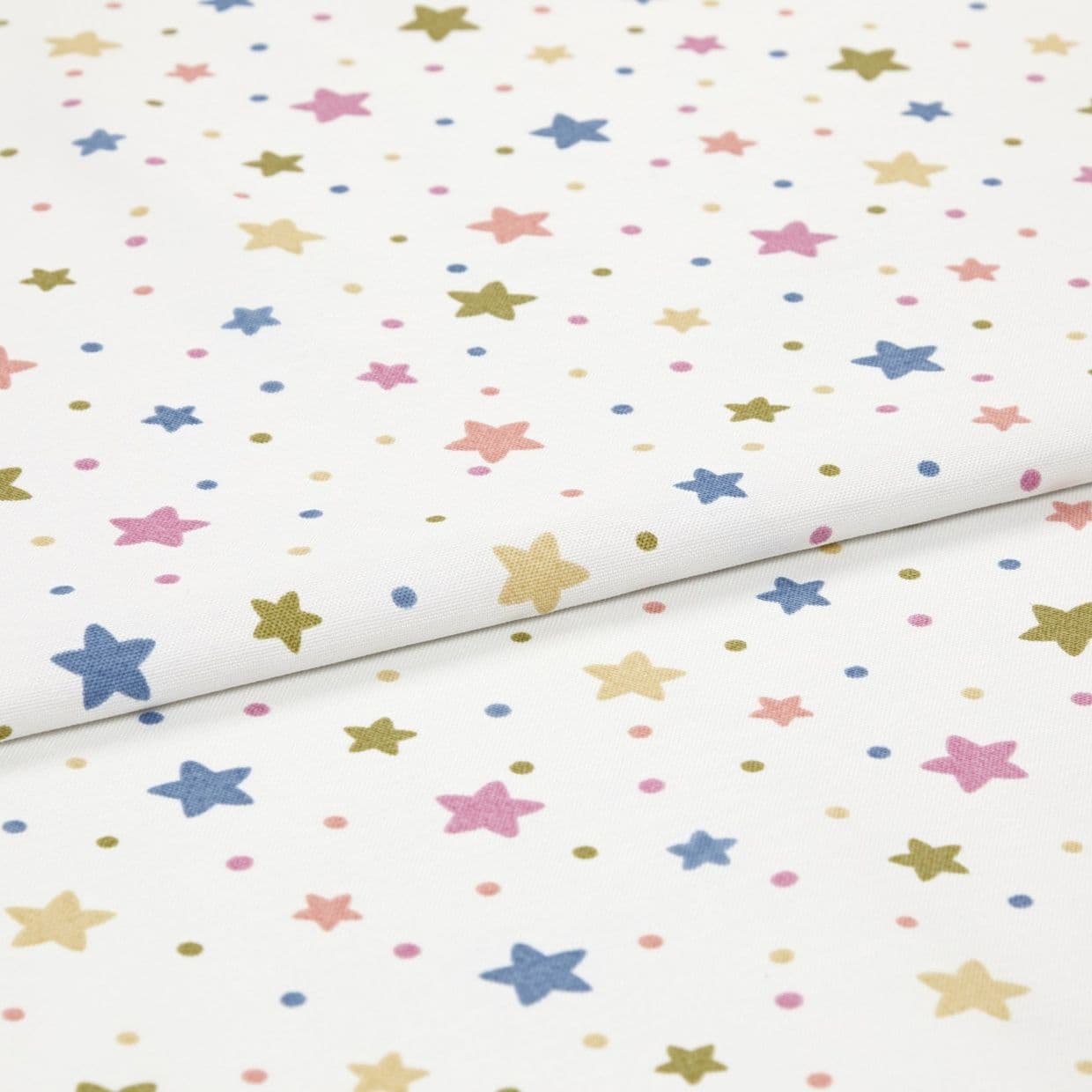 White cotton fabric with pastel star-and-dot print, folded and lying flat; small five-point stars and dots in blue, pink, yellow, olive; studio close-up, soft even lighting.