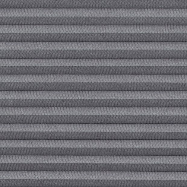 Gray pleated cellular blind, fully lowered with textured fabric forming horizontal ridges; blocking light and creating subtle shadow bands, shown in close-up interior view without visible window frame or exterior.