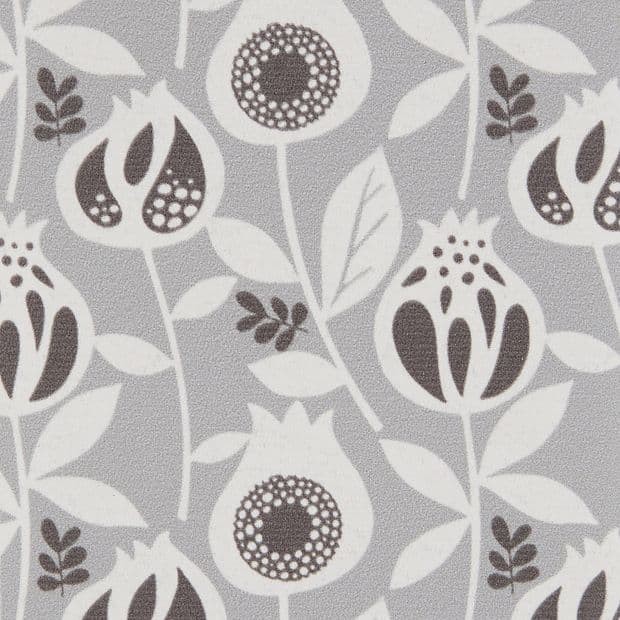 Wallpaper â€” light-gray, matte textured surface patterned with repeating stylized white and dark-gray pomegranate-like flowers and leaves; the motif repeats uniformly, covering a flat interior wall under even lighting.