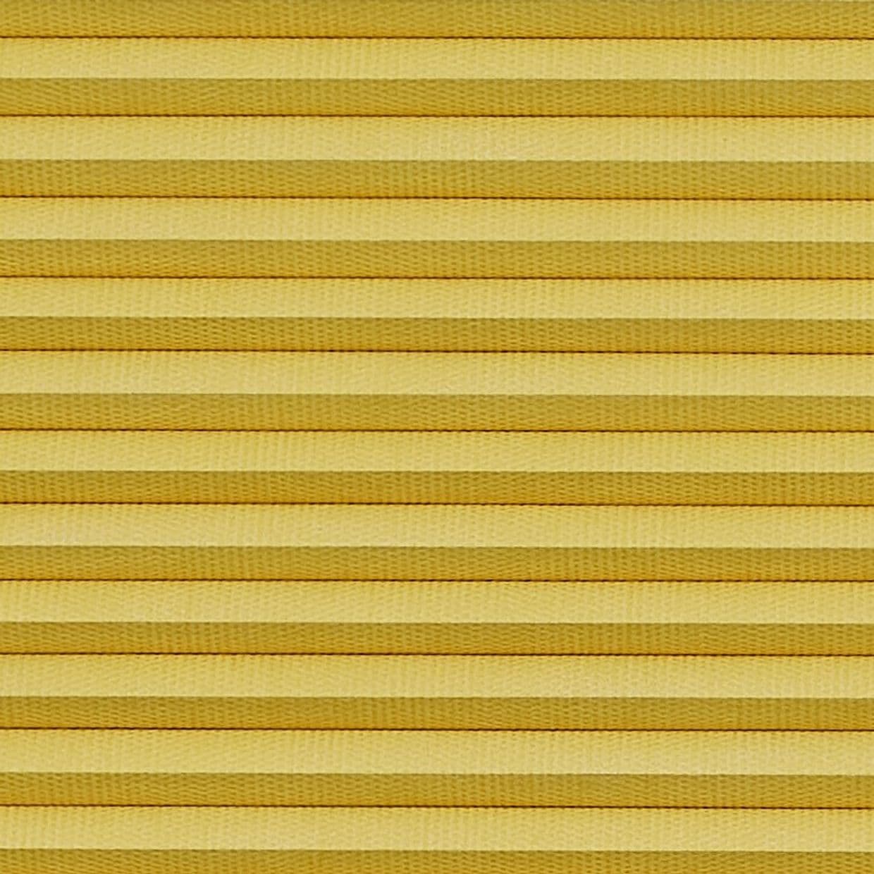 Horizontal cellular (honeycomb) pleated blind, closed with evenly spaced golden-yellow fabric folds and subtle texture; blocking light and insulating, filling the frame under warm diffuse lighting.