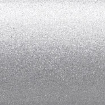 Silver metallic textured surface occupying the frame, scattering diffuse light with a subtle horizontal gradient; a flat, finely granulated panel in a neutral, evenly lit background.