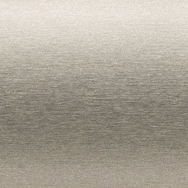 Brushed metal panel with fine horizontal grain; surface displays subtle sheen and faint gradient, reflecting soft diffuse light; close-up, neutral plain background with even studio lighting.