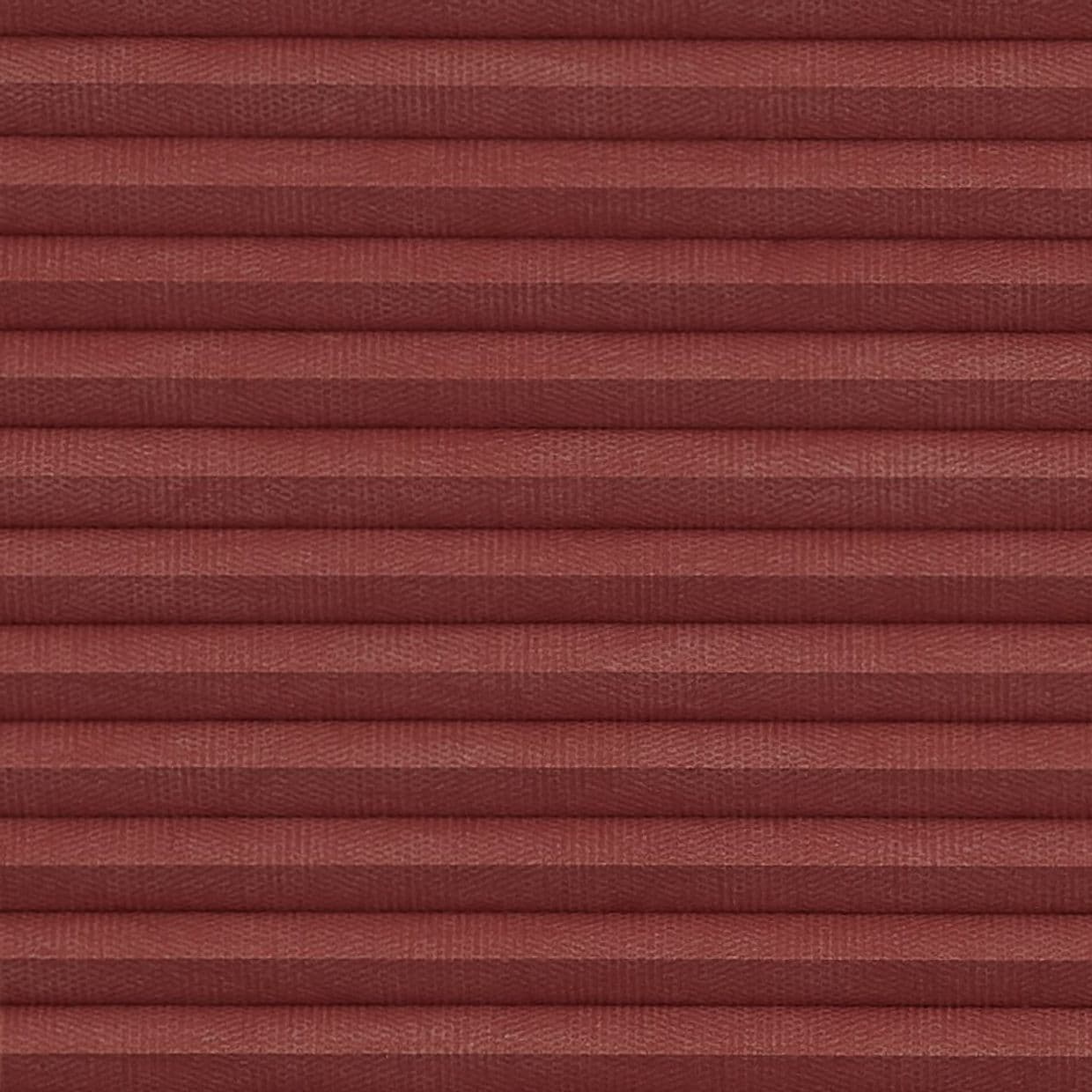 Burgundy fabric pleated blind with evenly spaced horizontal folds, fully lowered and closed, blocking light; close-up view shows woven texture and soft, diffuse indoor lighting.