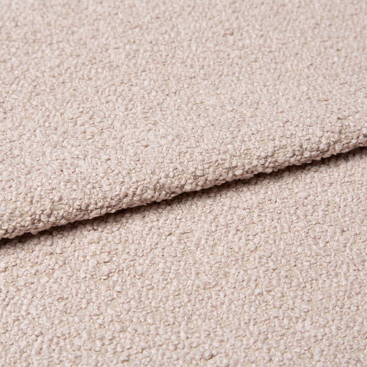 Beige bouclÃ© fabric with dense looped texture, folded over itself forming a soft ridge; close-up studio view of an upholstery/carpet sample under diffuse neutral lighting.