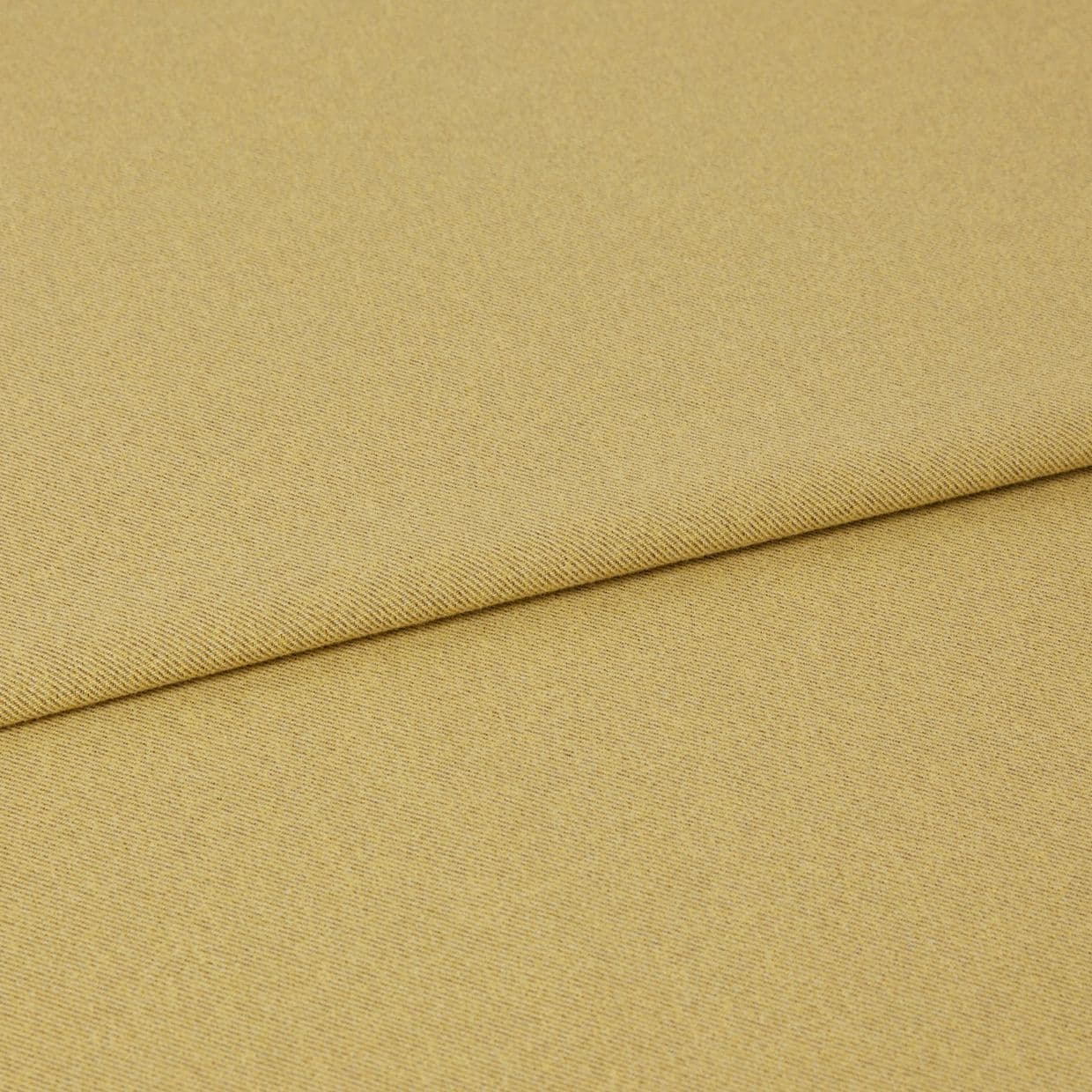 Mustard-yellow woven fabric folded with an overlapping edge near the upper third, showing subtle diagonal twill texture; close-up on a flat surface under even, neutral studio lighting.