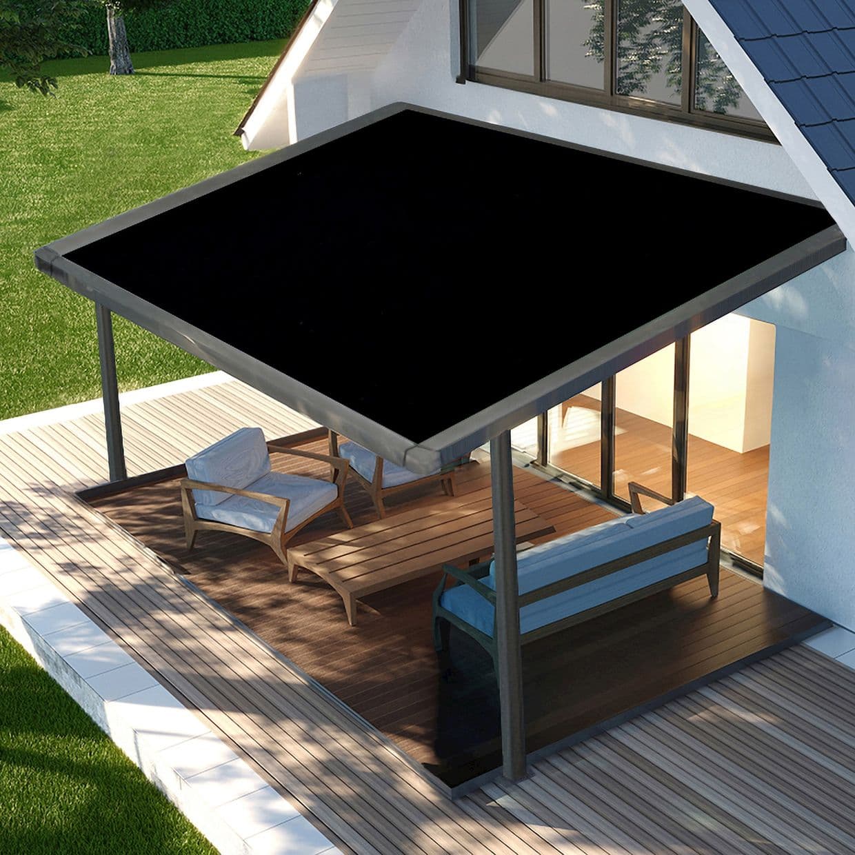 Rectangular black awning mounted above sliding glass doors, supported by metal posts; it extends over the deck, shading wooden lounge furniture on a sunlit patio beside a grassy yard.