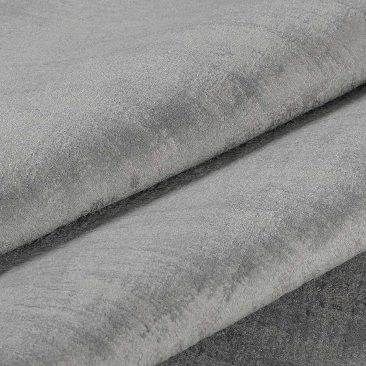 Folded grey plush velvet fabric, three overlapping layers with visible nap and subtle sheen; layered diagonally in a close-up product-style shot with soft, even lighting.