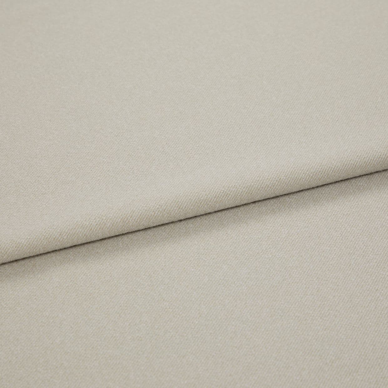 Beige woven fabric folded diagonally, overlapping to form a soft seam; close-up view with even, neutral lighting highlighting fine twill texture.
