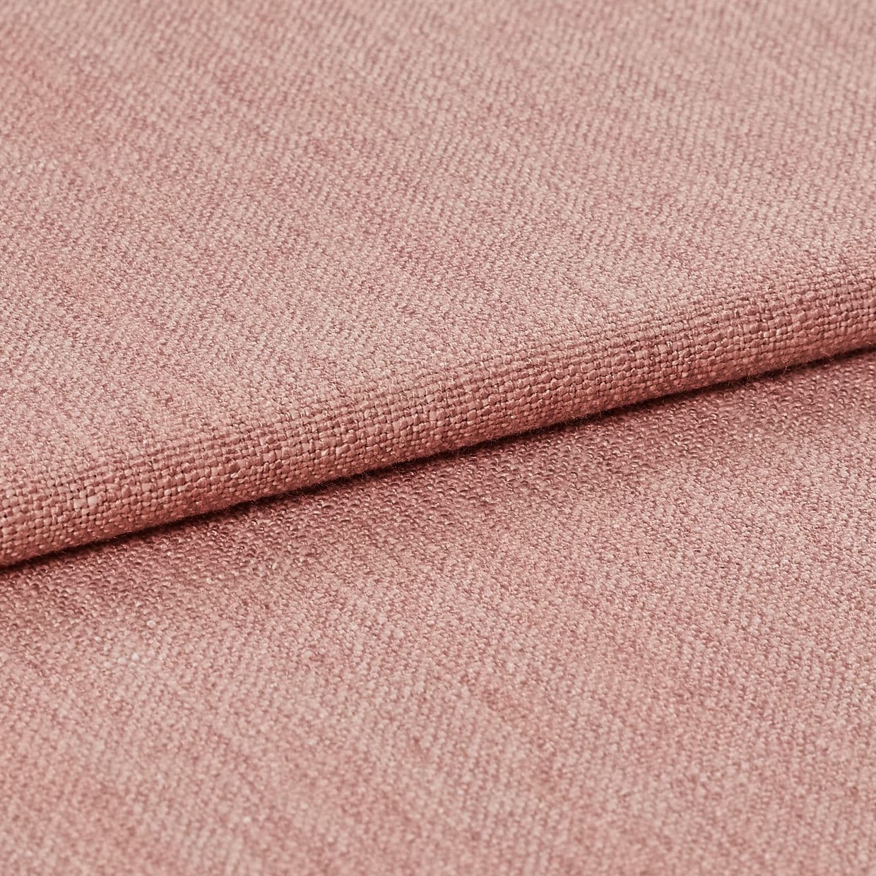 Pink woven upholstery fabric, tightly woven with visible grain and a folded edge, lying stacked; fabric displays subtle sheen and fine texture in a soft, evenly lit studio close-up.