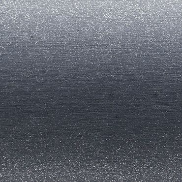 Brushed metallic surface with fine horizontal grain and small bright speckles â€” scattering diffuse light across the plane â€” macro close-up with even, cool-toned lighting, no other features visible.