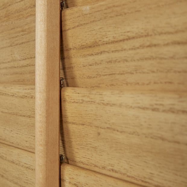 Wooden plantation shutters with a central vertical tilt rod and overlapping horizontal slats â€” closed, aligned to block light â€” close-up interior view showing warm wood grain and soft ambient light.