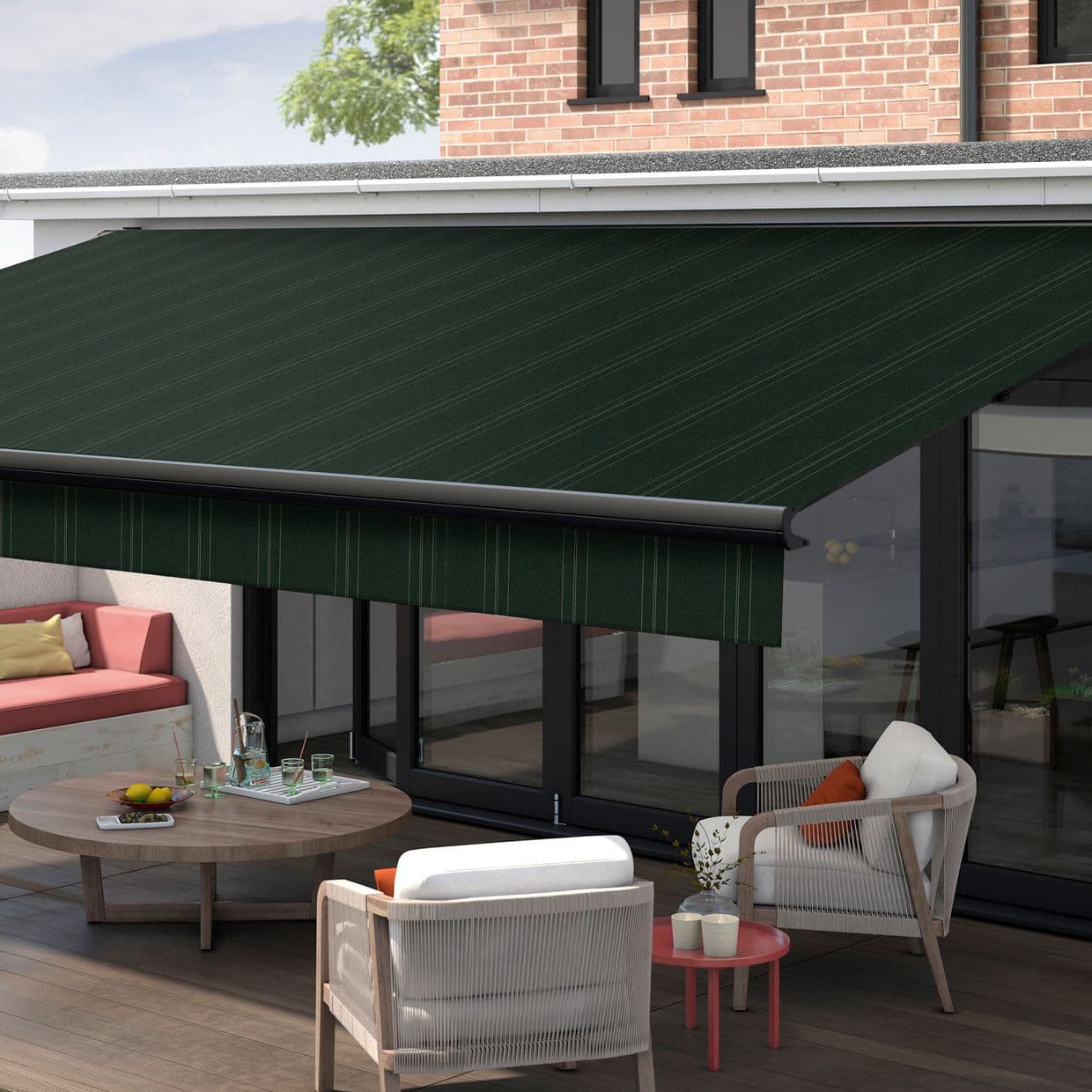 Dark green striped retractable awning, fully extended above glass patio doors with valance, shading an outdoor seating area on a sunny, brick-walled terrace.