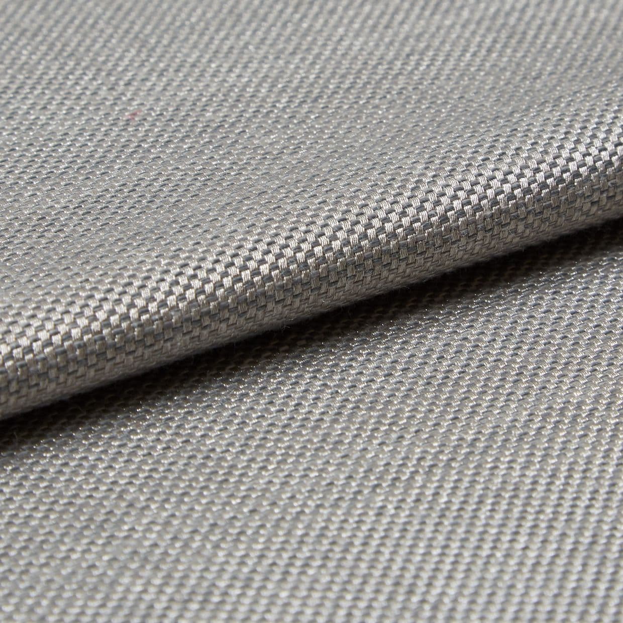 Close-up of woven silverâ€‘grey fabric (tight basket weave) folded over itself; the fold creates a horizontal overlap, lit evenly to emphasize fine texture and subtle metallic sheen in a neutral setting.
