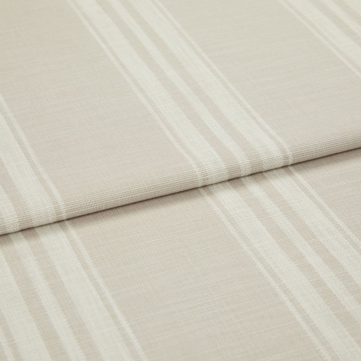 Beige-and-cream striped fabric, folded in layered horizontal pleats; woven texture visible; close-up view with soft, diffuse lighting on a neutral surface.