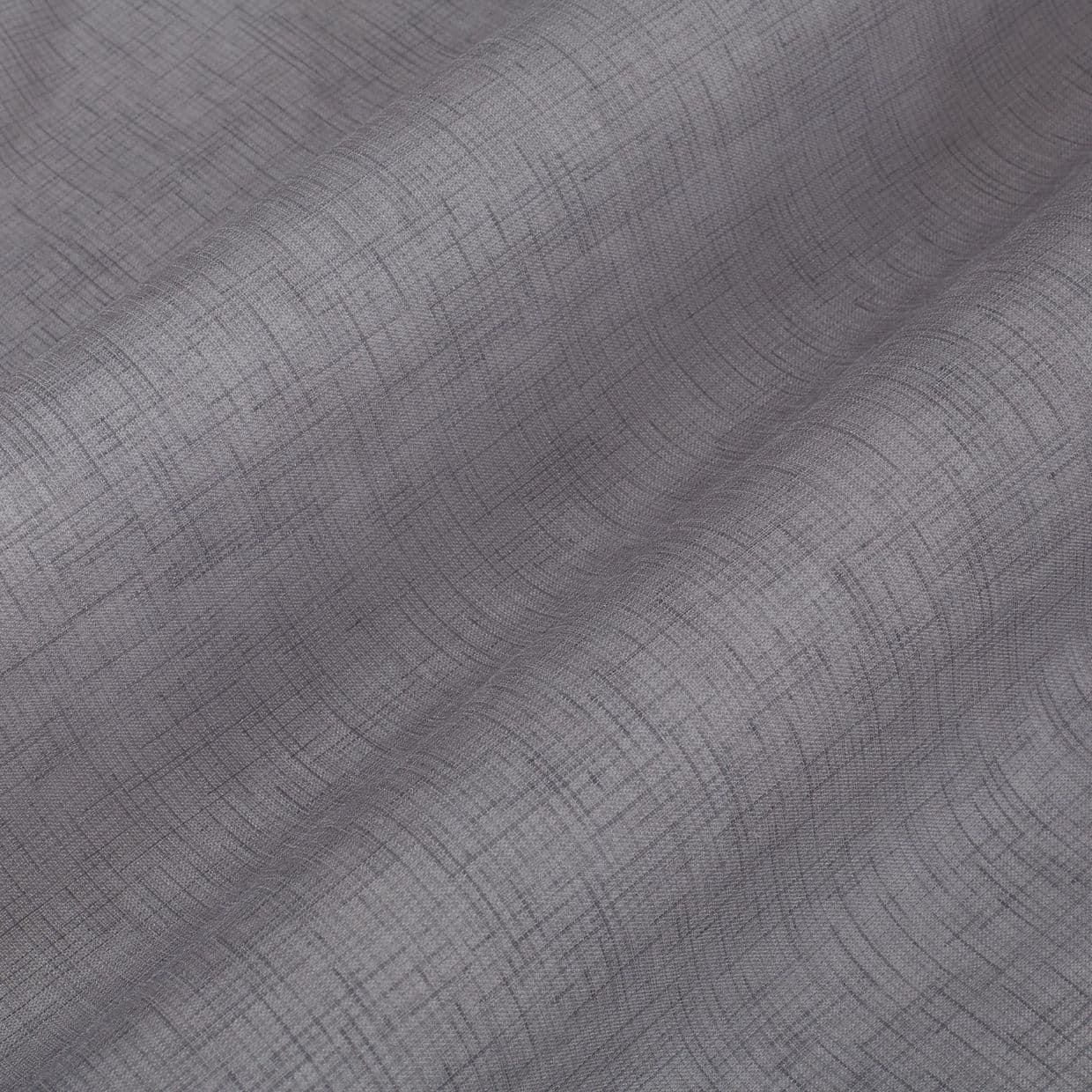 Textured gray curtain panel with fine crosshatch pattern, draped in soft vertical folds, gently filtering light against a neutral, softly lit interior.