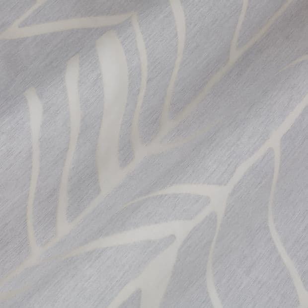 Pale gray curtain fabric with white abstract leaf pattern, draped in soft diagonal folds; fabric appears slightly textured and creased, shown in a close-up under soft, neutral indoor lighting.