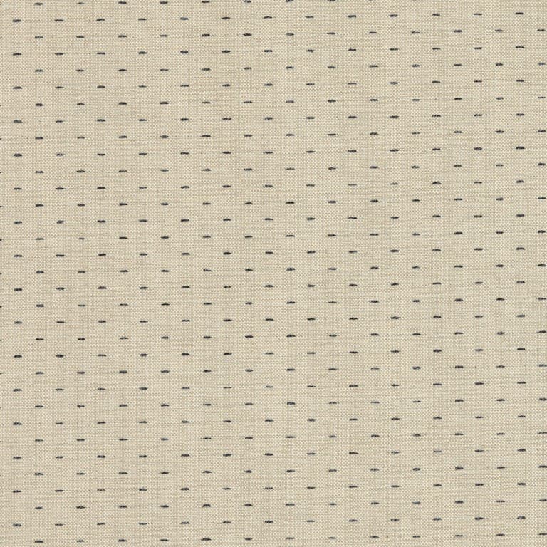 Beige woven fabric patterned with evenly spaced short navy-blue stitch dashes; close-up view showing textured weave and a subtle vertical seam, likely upholstery or curtain material in neutral indoor lighting.