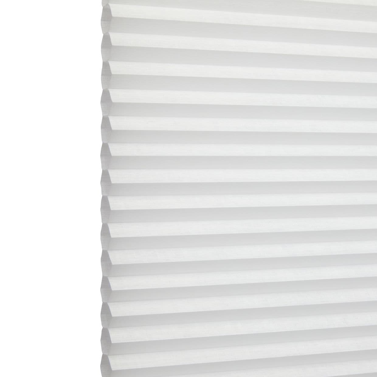 White honeycomb (cellular) blind with horizontal pleats, closed and softly diffusing daylight; minimal, bright interior with no visible furniture or view.
