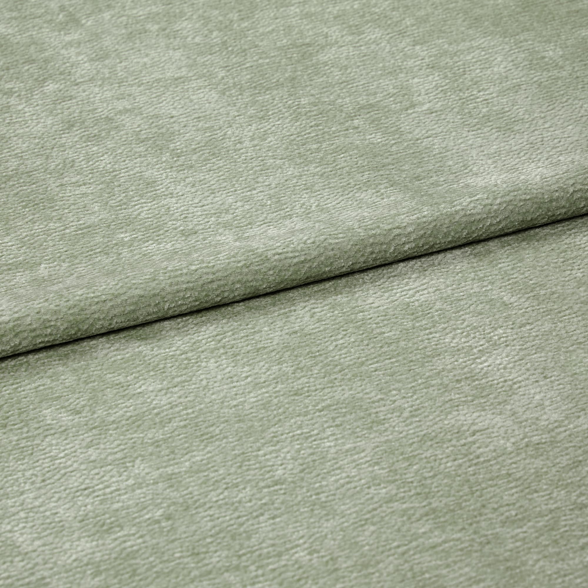 Velvet-like pale sage-green fabric folded horizontally, creating an overlapping seam; soft, short-pile texture; close-up, evenly lit studio view filling the frame.