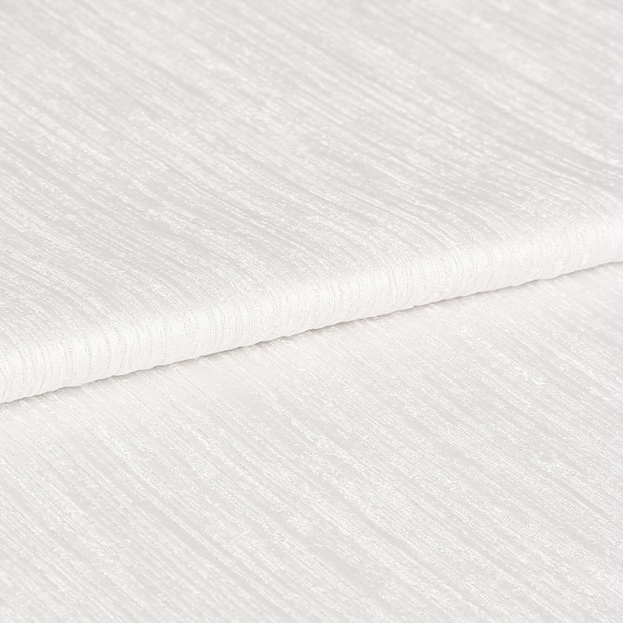White ribbed textured fabric, folded in overlapping layers showing subtle horizontal sheen; lying stacked on itself, photographed in close-up under soft, even studio lighting with a neutral background.