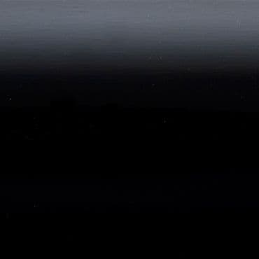 Horizontal dark gradient panel (object) showing faint horizontal banding and tiny light specks, appearing smooth and slightly reflective (action); occupying the entire frame in an abstract, low-light scene (context).