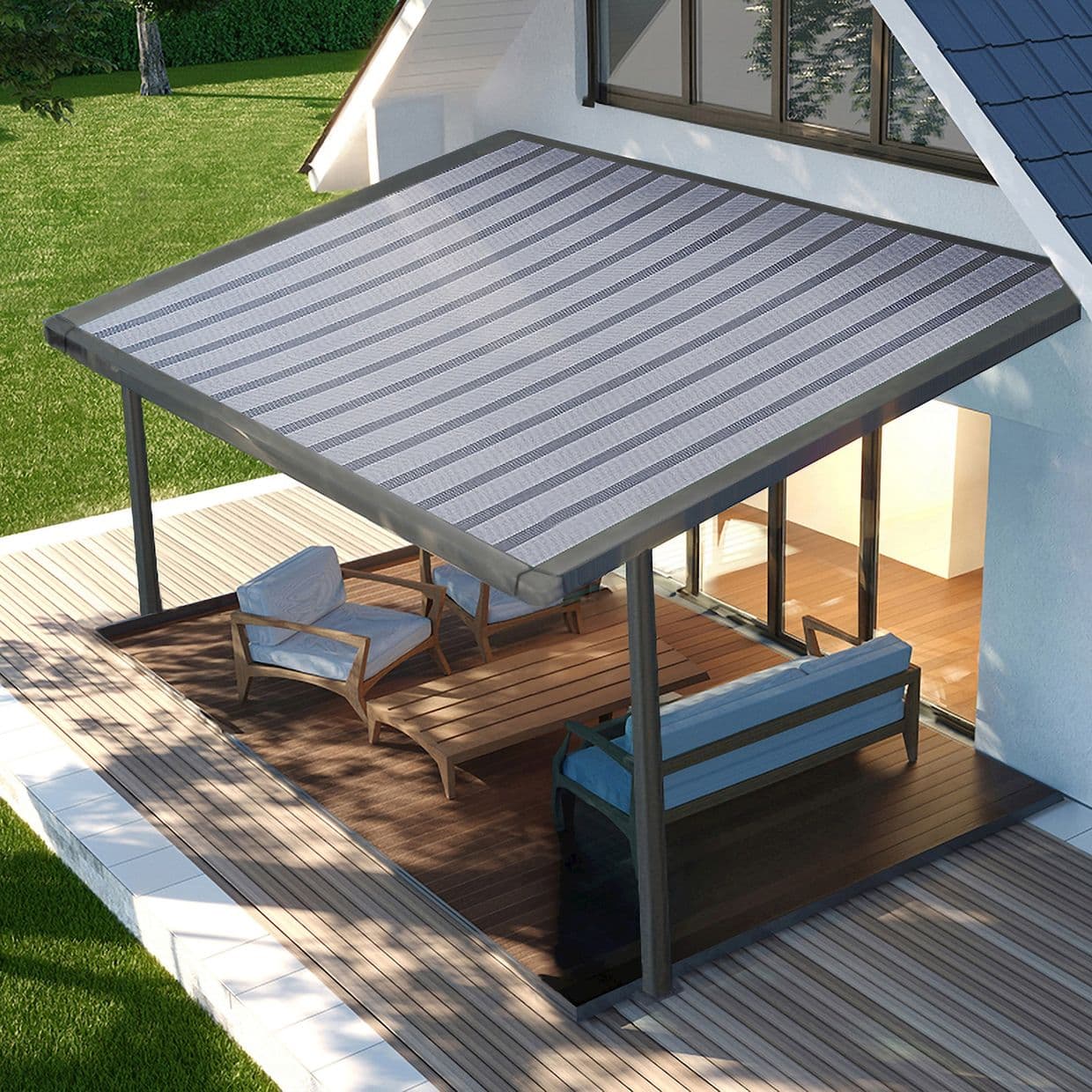 Striped fabric patio awning mounted to the house and supported by metal posts, shading the seating area; covering an outdoor wooden deck with lounge chairs beside sliding glass doors, sunlit lawn beyond.