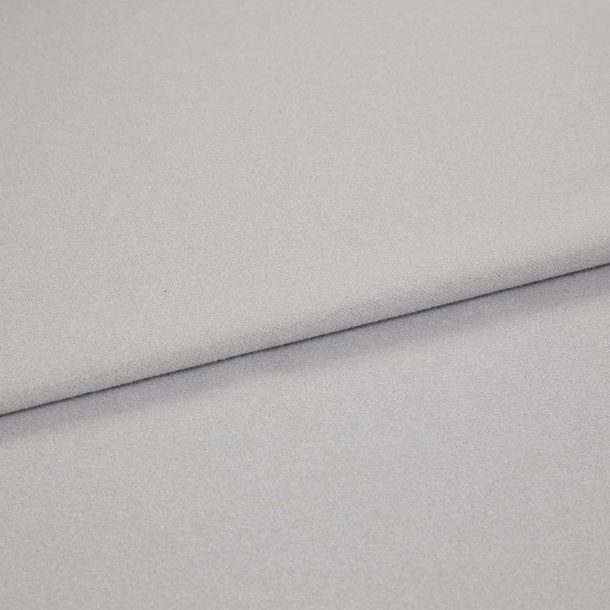 Light gray, soft-textured fabric folded diagonally across the frame, creating an overlapping edge; close-up view with diffuse, even lighting on a neutral background.