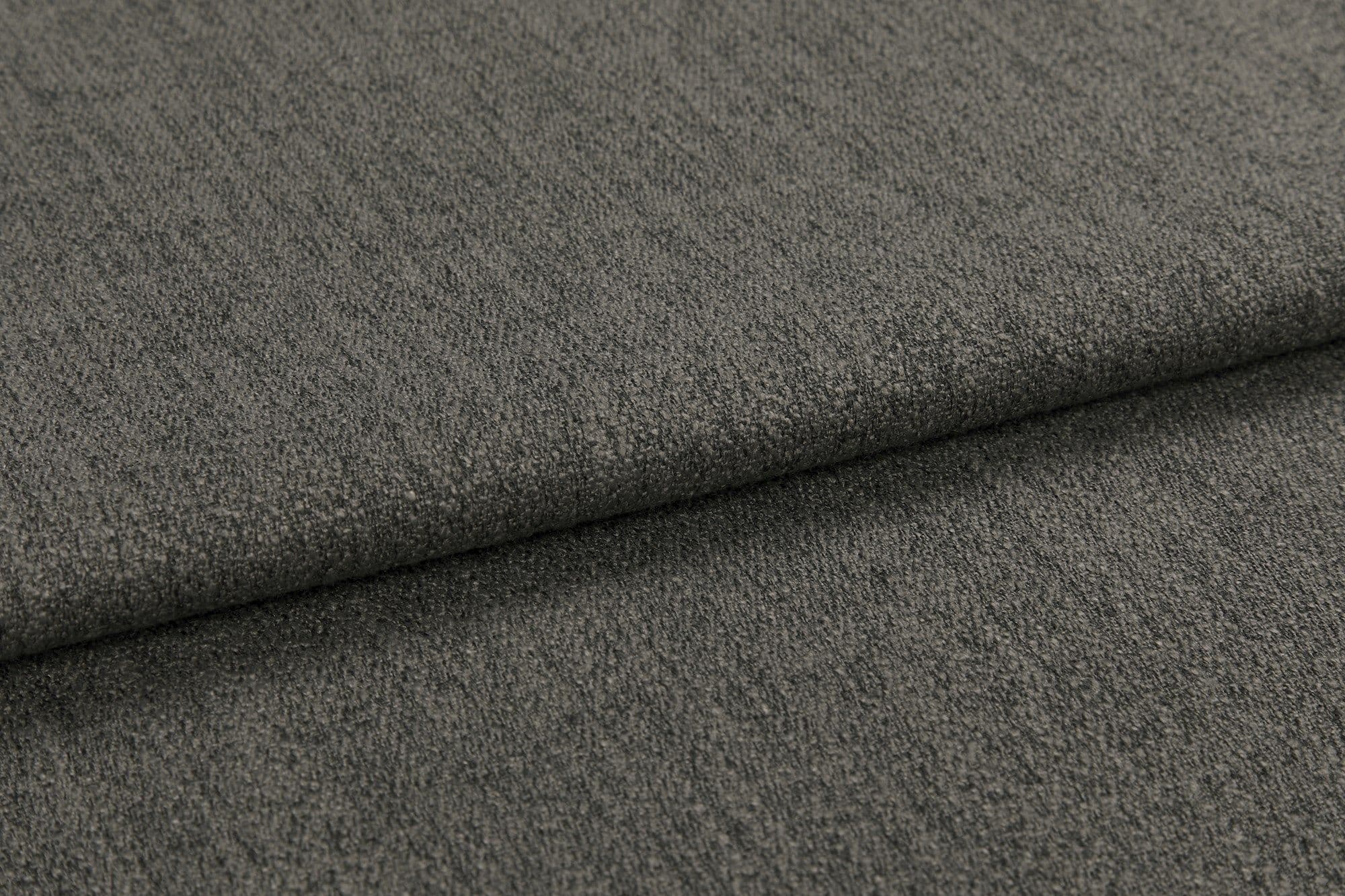 Gray textured upholstery fabric, folded over itself forming a horizontal overlap; revealing tight weave and slight nap; close-up view under soft, even lighting.