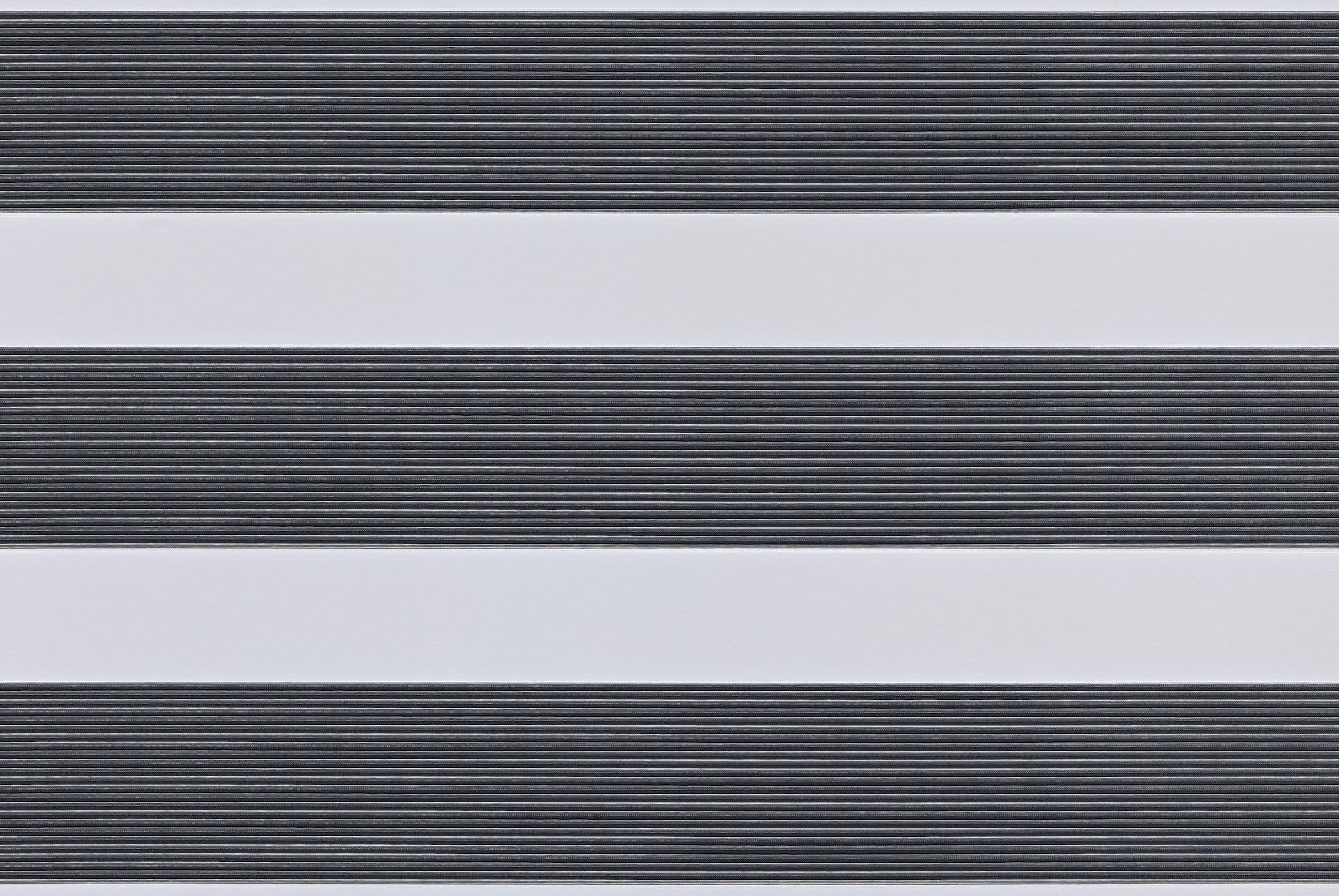 Dual-layer horizontal zebra roller blind mounted across the frame, aligned into alternating wide opaque white bands and narrow ribbed dark-gray slats, partially filtering light; interior close-up with soft even lighting.