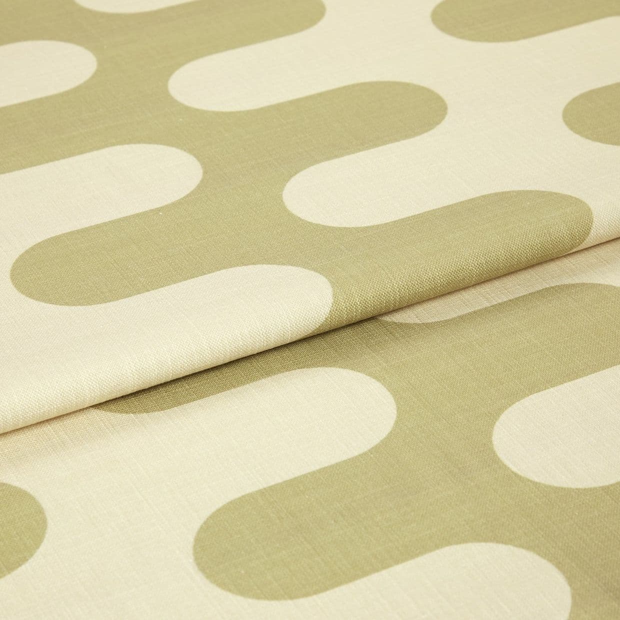 Fabric with large oliveâ€‘green rounded geometric motifs, folded and layered, showing woven texture and seams; studioâ€‘lit close-up of a neutralâ€‘colored textile sample.