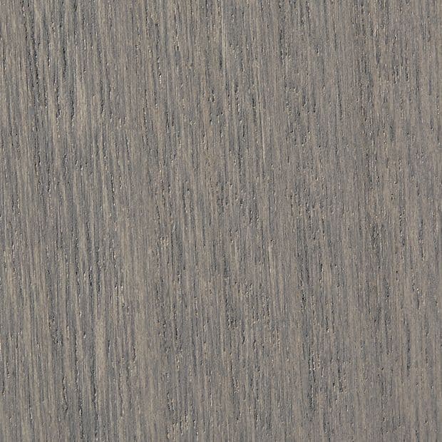 Gray-stained oak veneer with tight vertical grain and subtle knots, showing fine parallel striations and slight weathering, filling the frame as a studio-lit close-up sample.