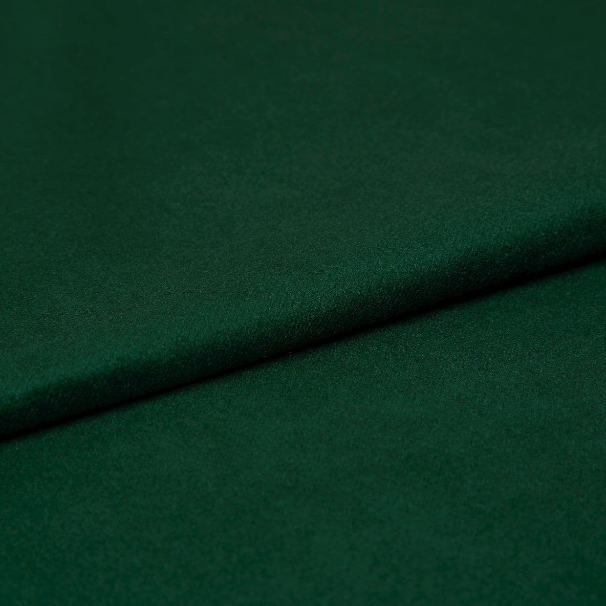Deep emerald green felt fabric, folded once creating a soft overlapping seam; close-up studio view showing fine texture, matte finish, and even, subdued lighting.